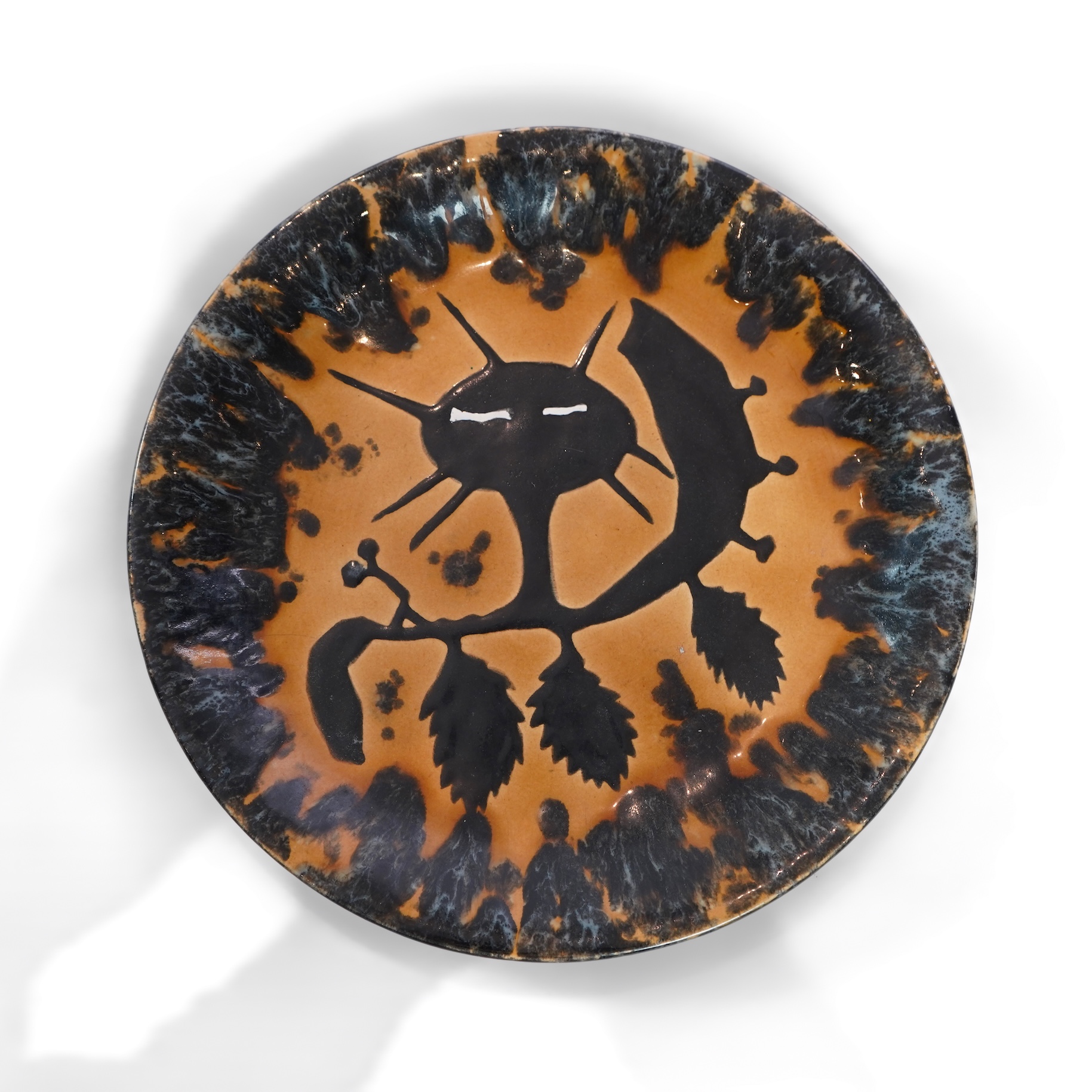 Jean Lurçat (1892-1966): An ochre and black glazed earthenware plate, decorated with a stylised central figure